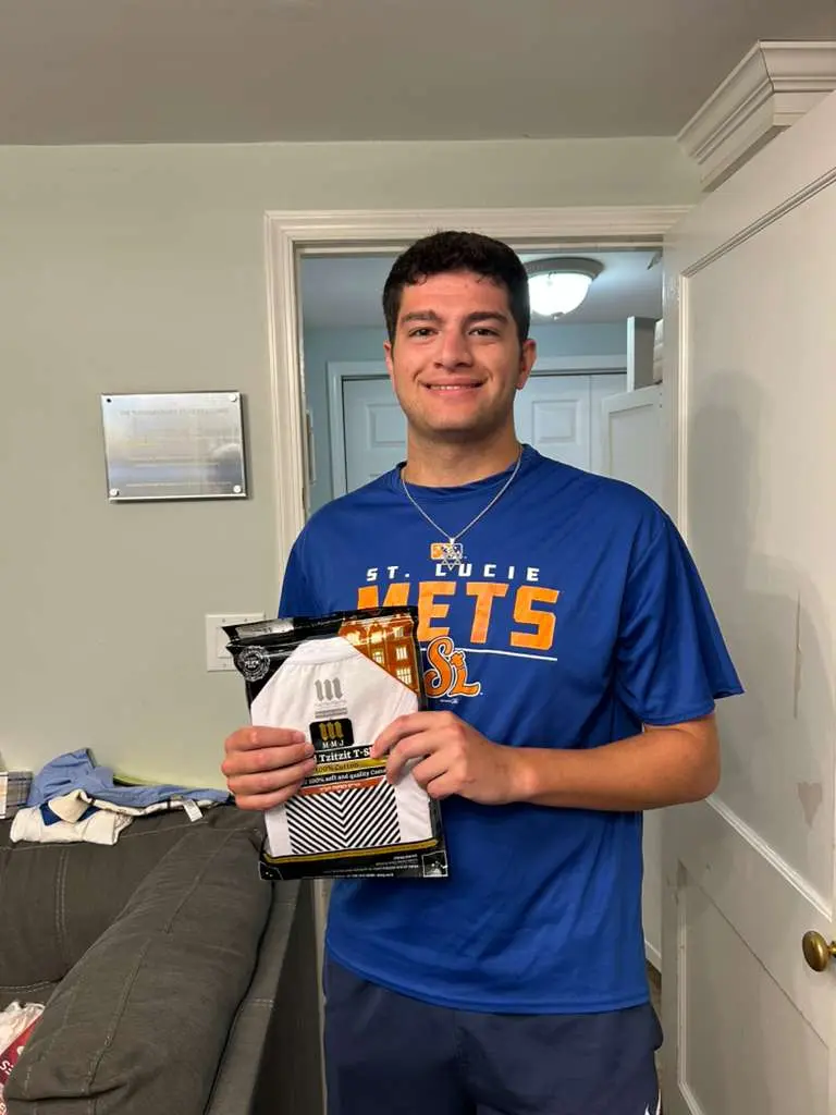 Jewish college student holding a Dri-Fit tzitzit shirt